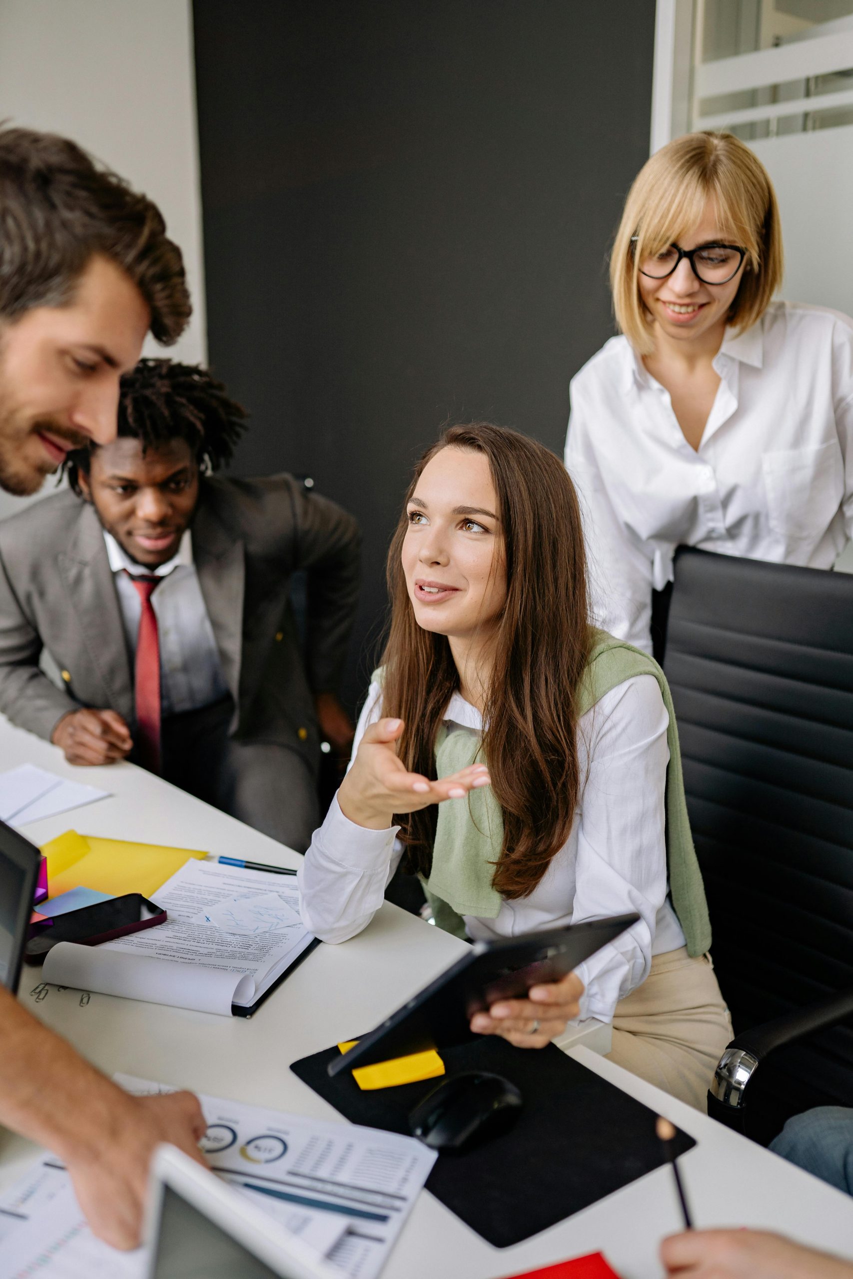 A multi-ethnic team brainstorming and collaborating in a modern office setting.