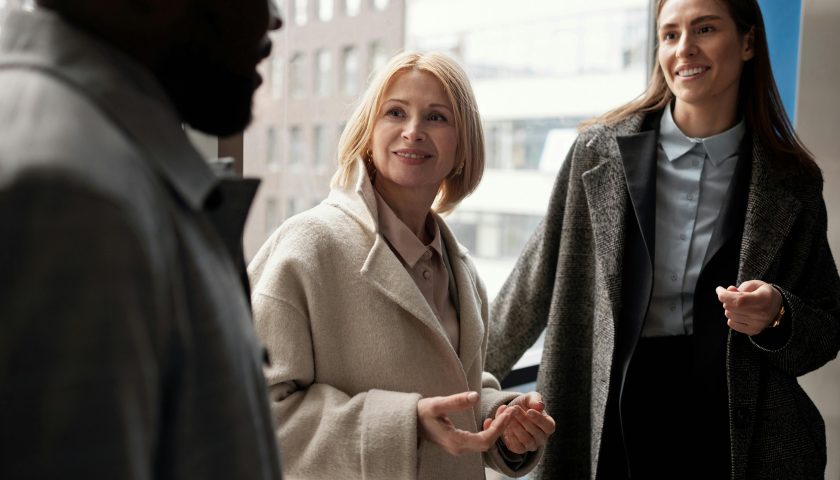 A diverse group of business professionals conversing in an urban office setting.